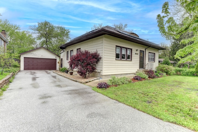 view of front facade featuring an outbuilding, a garage, and a front lawn