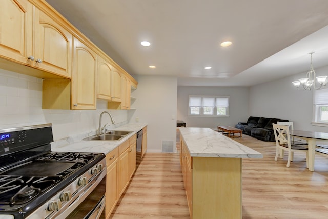 kitchen featuring plenty of natural light, light hardwood / wood-style flooring, backsplash, and gas range