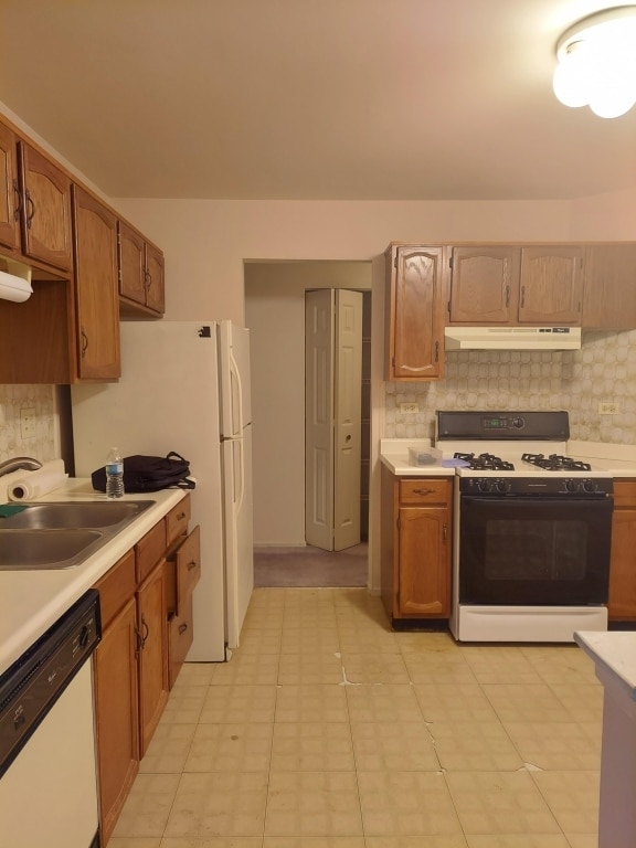 kitchen featuring light tile patterned flooring, sink, white appliances, and backsplash