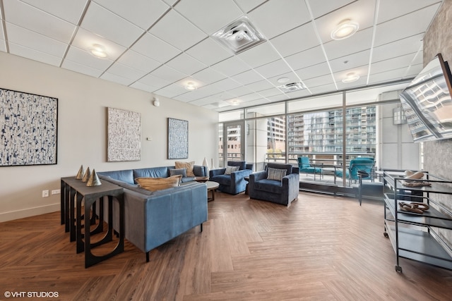 living room with parquet floors, floor to ceiling windows, and a paneled ceiling