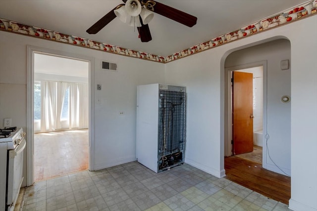 tiled spare room featuring ceiling fan