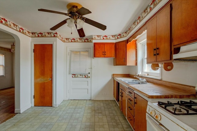 kitchen featuring white stove, sink, light wood-type flooring, ventilation hood, and ceiling fan