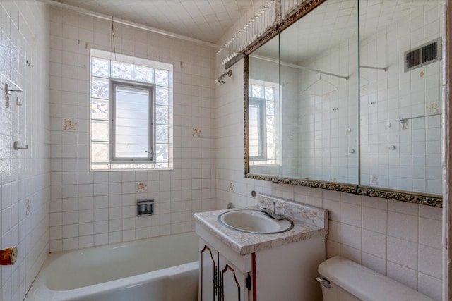 full bathroom featuring a healthy amount of sunlight, vanity, tile walls, and toilet