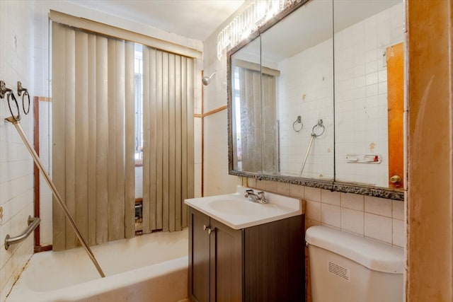 full bathroom with vanity, toilet, shower / washtub combination, and tile walls