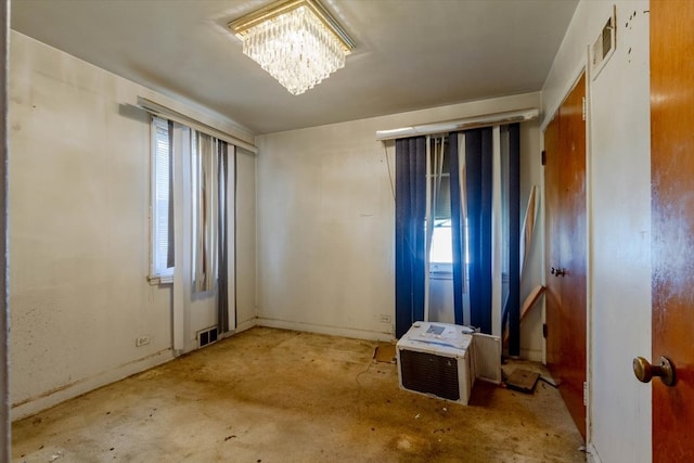 unfurnished room featuring an inviting chandelier