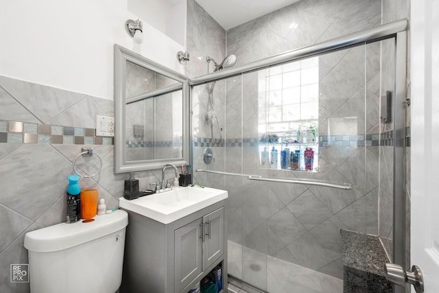 bathroom with vanity, toilet, and a shower with door