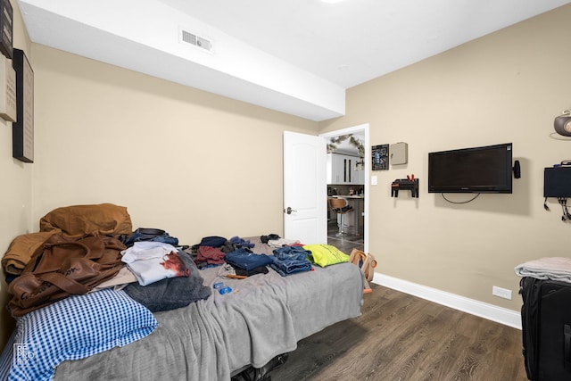 bedroom with dark hardwood / wood-style flooring