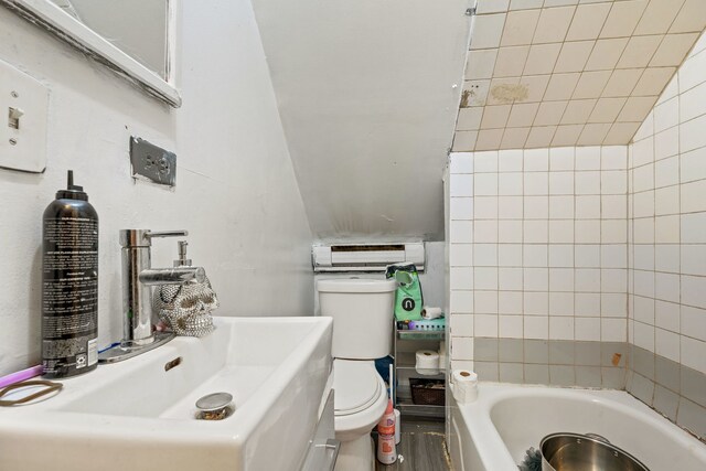 bathroom with sink, lofted ceiling, and toilet