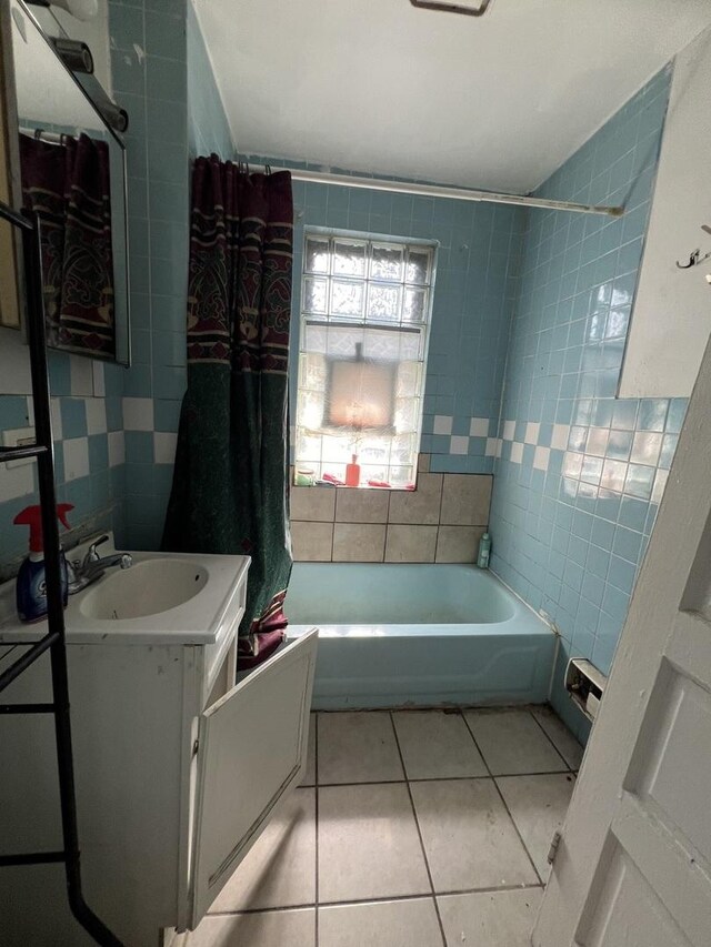 bathroom with shower / tub combo with curtain, vanity, tile patterned floors, and tile walls