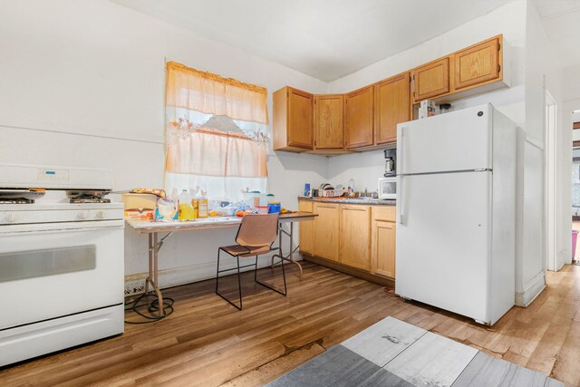 kitchen with light hardwood / wood-style flooring and white appliances