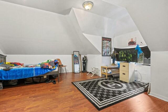 bedroom with vaulted ceiling and hardwood / wood-style floors