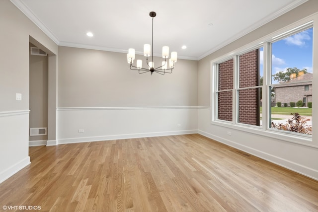 unfurnished room featuring light hardwood / wood-style floors, ornamental molding, and a chandelier