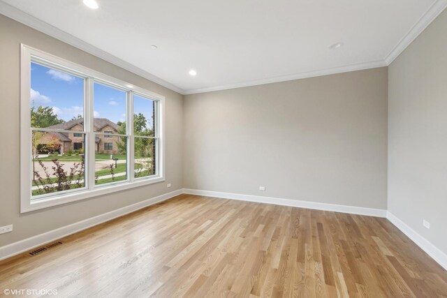 empty room featuring light hardwood / wood-style floors and crown molding