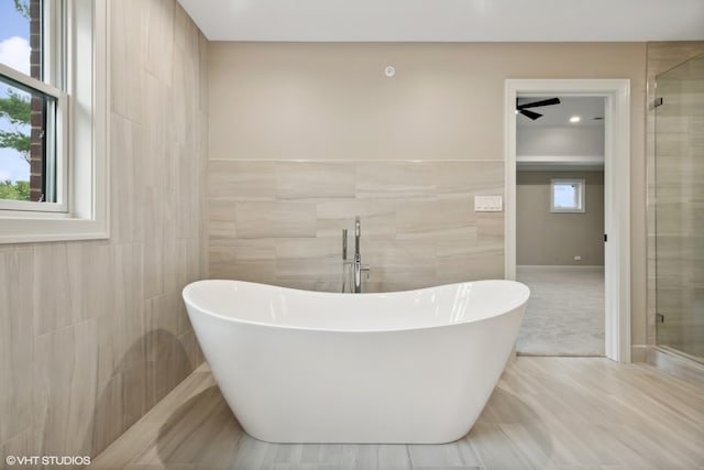 bathroom featuring independent shower and bath, tile patterned floors, and tile walls