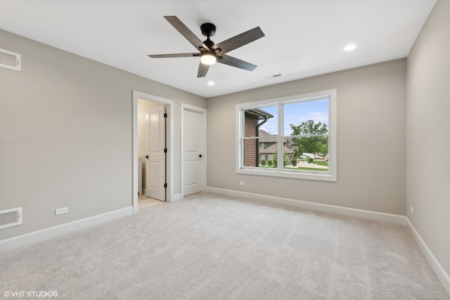 unfurnished bedroom featuring ensuite bath, light colored carpet, and ceiling fan