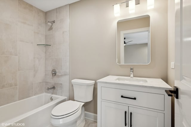 full bathroom featuring tiled shower / bath combo, toilet, vanity, and ceiling fan