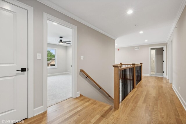 corridor featuring crown molding and light carpet