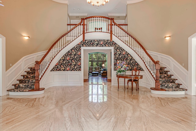 stairway with light tile patterned flooring, a towering ceiling, and crown molding