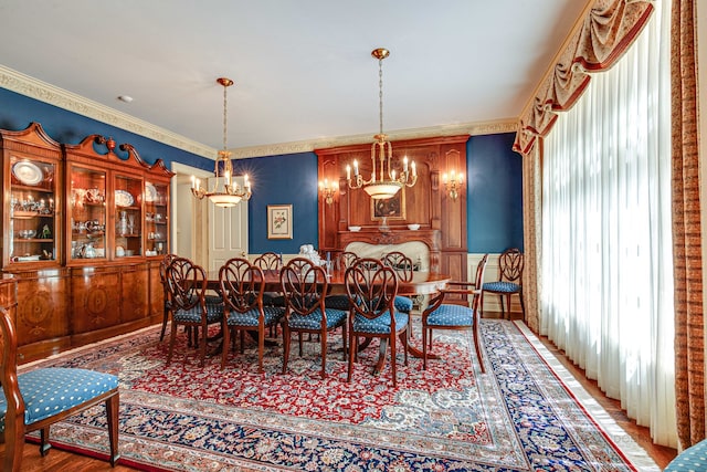 dining room featuring wood-type flooring, crown molding, and a chandelier