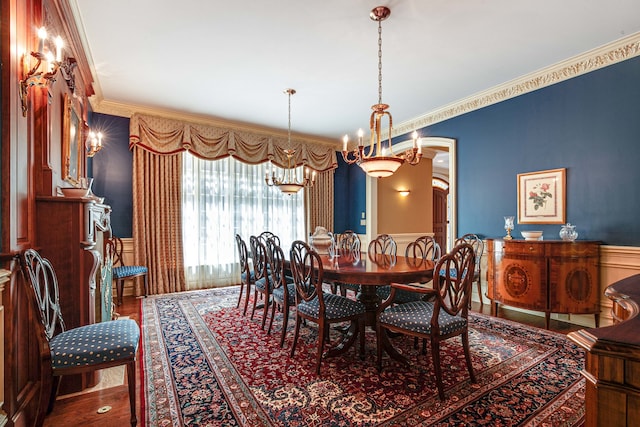 dining area with hardwood / wood-style flooring, crown molding, and a chandelier