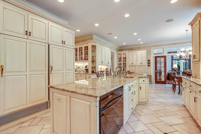 kitchen featuring cream cabinets, sink, and a center island with sink