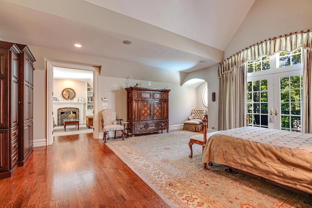 bedroom featuring high vaulted ceiling, access to outside, french doors, and hardwood / wood-style flooring