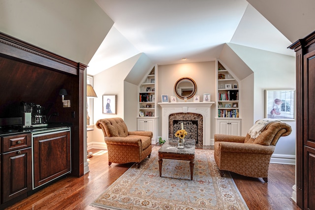 living room featuring built in features, a fireplace, and dark hardwood / wood-style floors