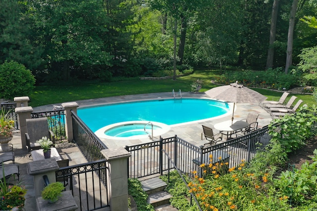 view of pool with a patio, an in ground hot tub, and a lawn