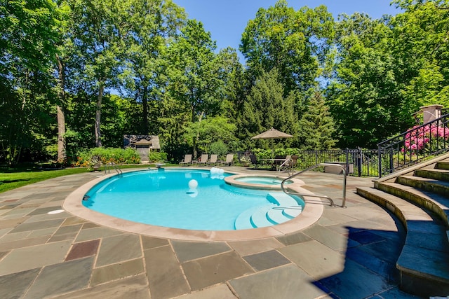 view of swimming pool featuring a patio area and an in ground hot tub