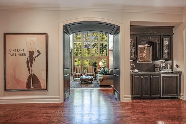 546 Lakeland Dr, Lake Bluff, IL 60044 - doorway to outside with bar with sink, dark wood-type flooring, arched walkways, ornamental molding, and baseboards