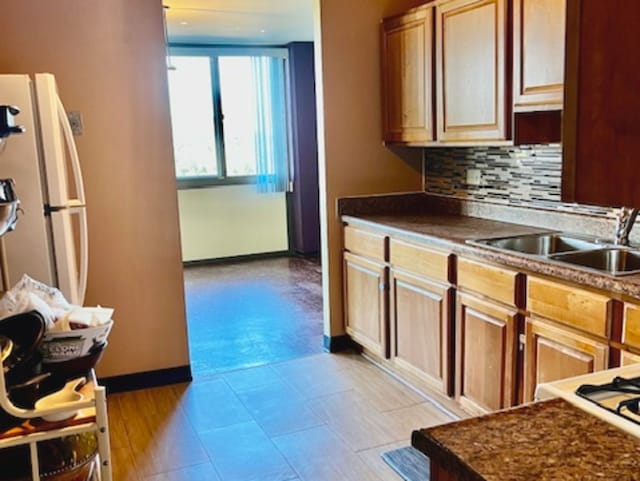 kitchen with sink, white fridge, and tasteful backsplash