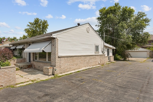 view of side of property featuring a garage and an outbuilding