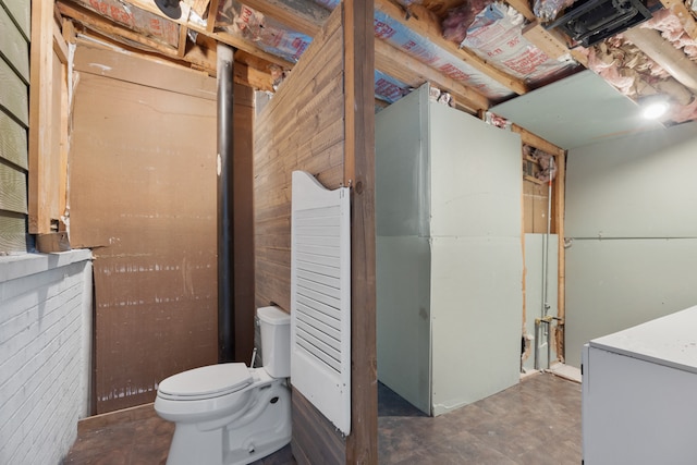 bathroom featuring toilet and wooden walls