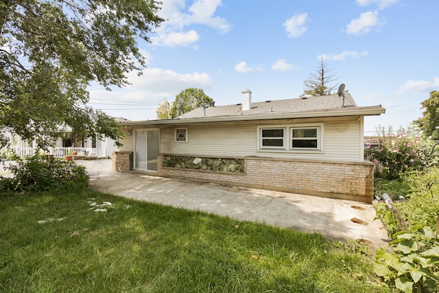 back of house featuring a patio and a yard