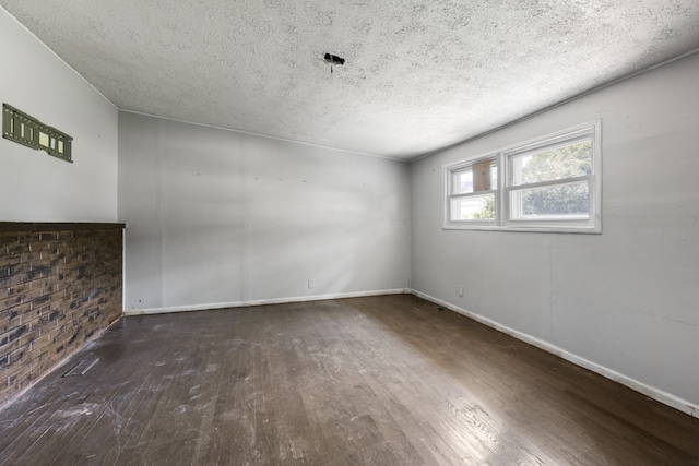 unfurnished room featuring a textured ceiling and dark hardwood / wood-style floors