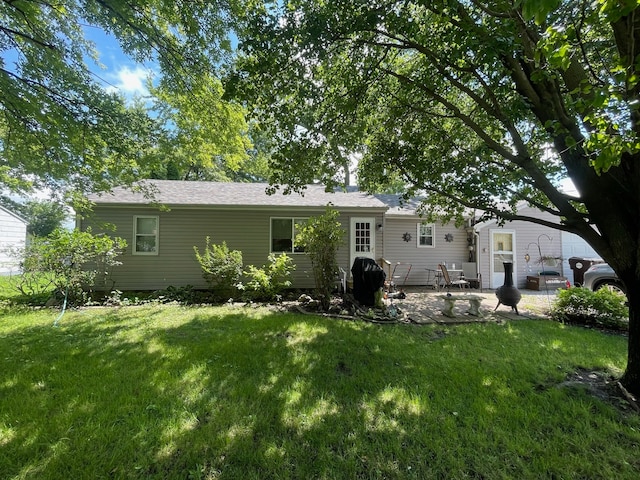 rear view of house featuring a patio and a lawn