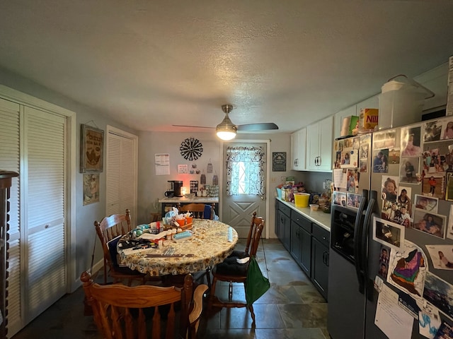 tiled dining room featuring a textured ceiling and ceiling fan