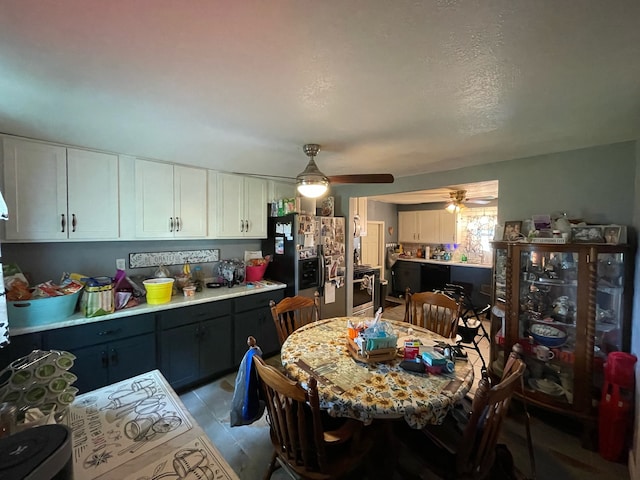 kitchen with white cabinets, wall oven, light tile patterned floors, stainless steel fridge with ice dispenser, and ceiling fan