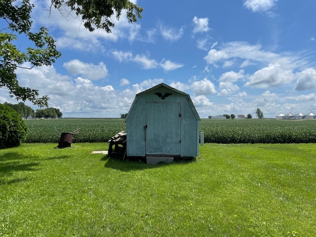 view of outdoor structure featuring a yard and a rural view