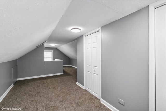 bonus room with carpet, vaulted ceiling, and a textured ceiling