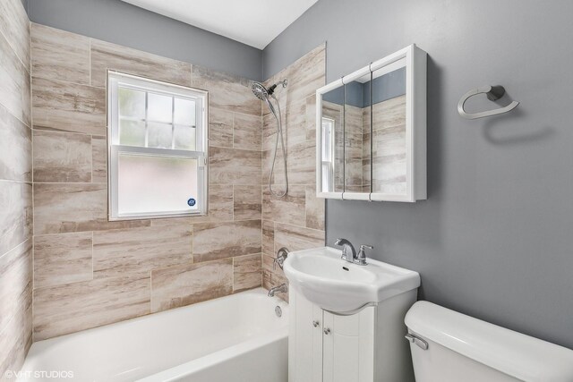 full bathroom with toilet, vanity, and tiled shower / bath