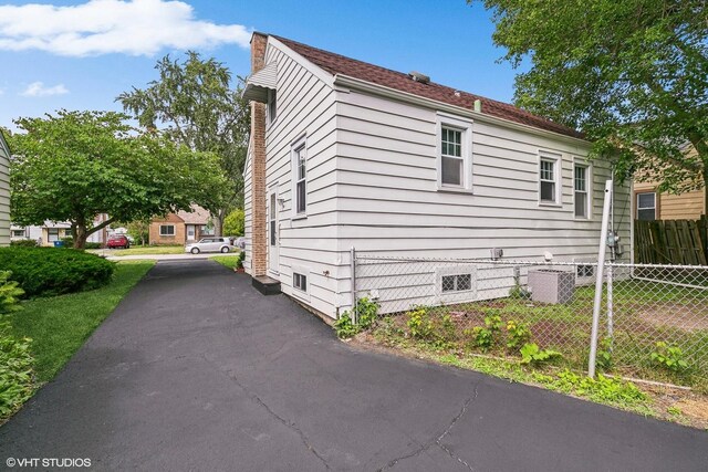 view of side of home with central AC