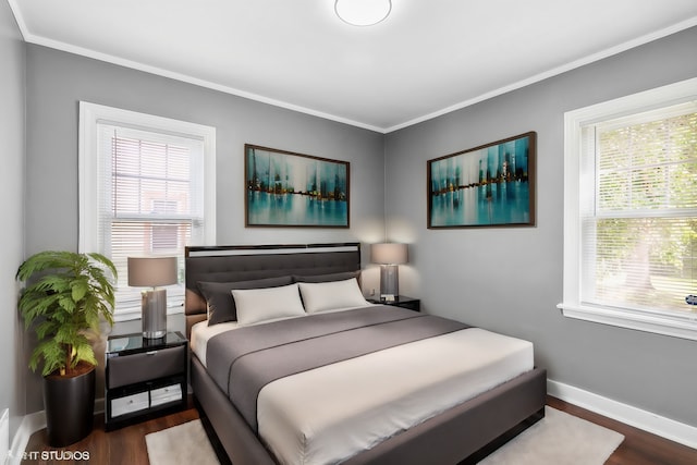 bedroom featuring dark wood-type flooring, crown molding, and multiple windows