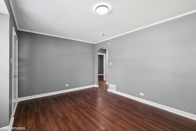 empty room with hardwood / wood-style flooring and crown molding