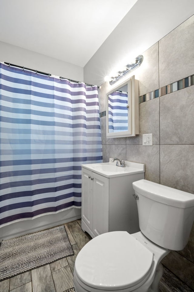 full bathroom with vanity, shower / bath combination with curtain, toilet, and tile walls