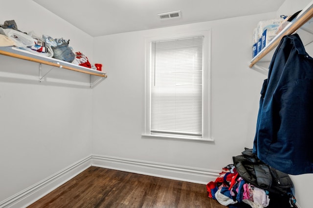 walk in closet with dark wood-type flooring