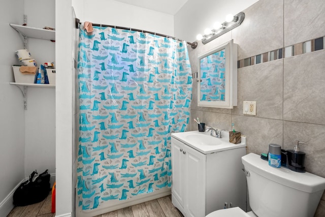 bathroom featuring vanity, toilet, and tile walls