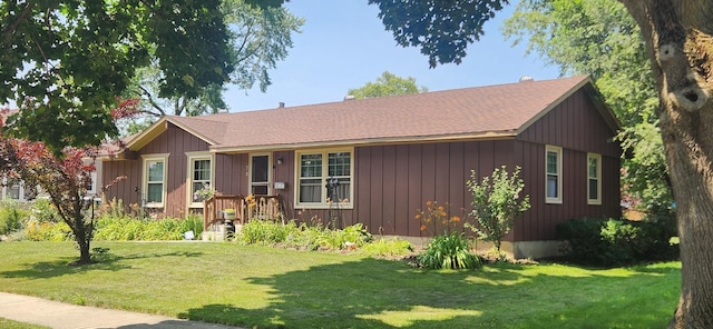 ranch-style home featuring board and batten siding and a front yard