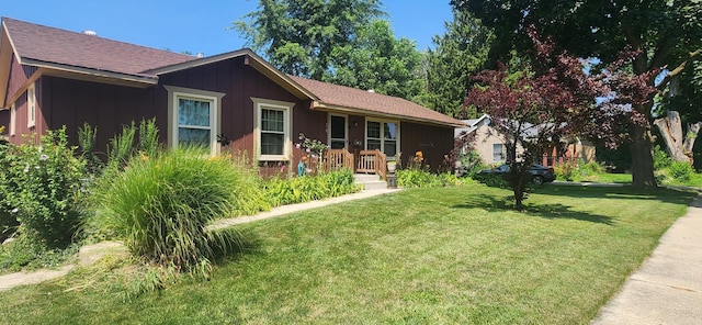 ranch-style home with board and batten siding and a front lawn