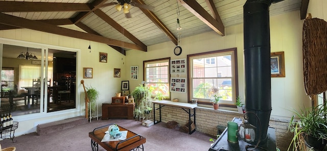 interior space with lofted ceiling with beams, ceiling fan, wooden ceiling, and a wood stove